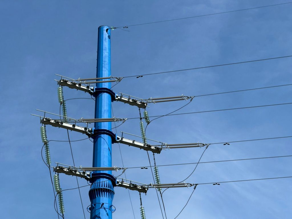 a tall blue pole with lots of wires attached to it